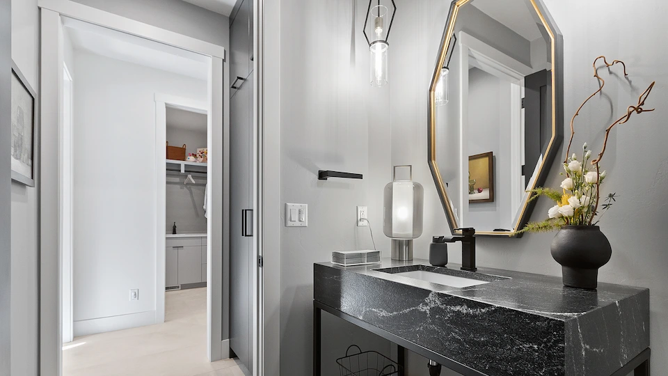 bathroom with lit up mirrors and brick wall