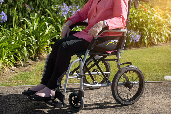 older lady in a wheelchair outside of renovated senior living center