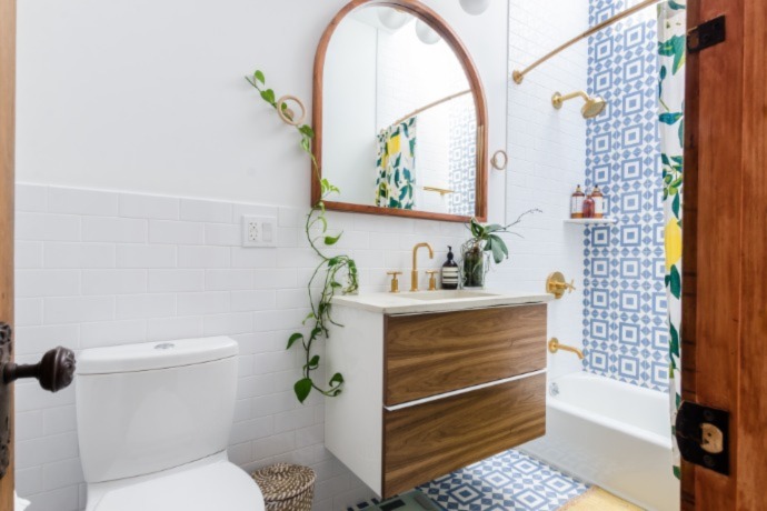 small bathroom with added blue and yellow colors with natural wood and plants 