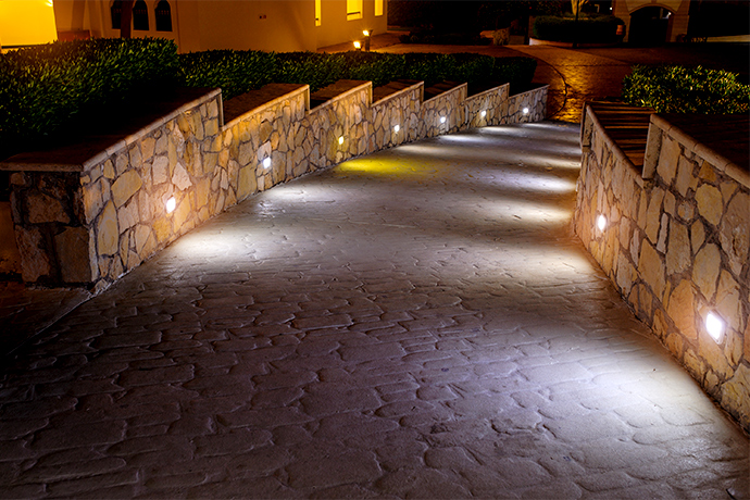 a driveway to the house with landscape lighting