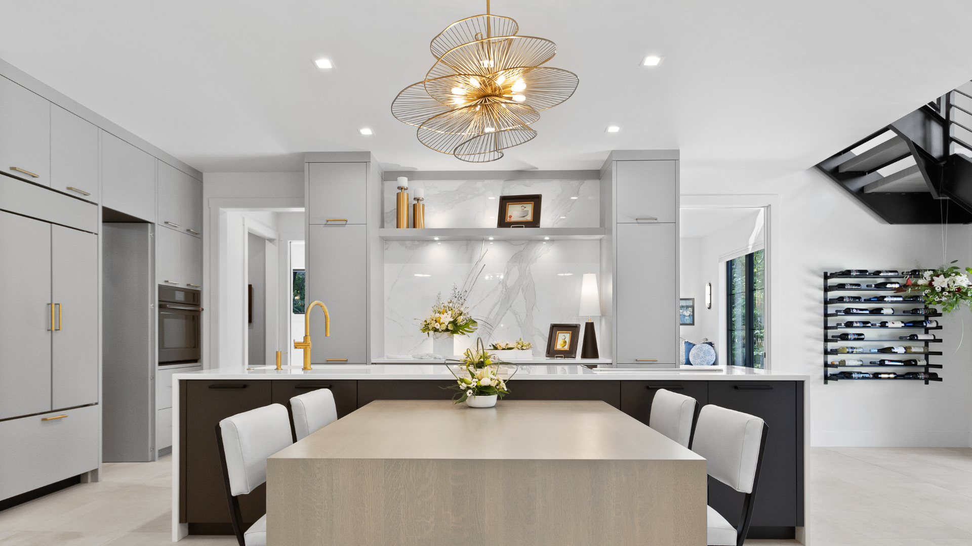 Bright modern kitchen and dining space with warm chandelier