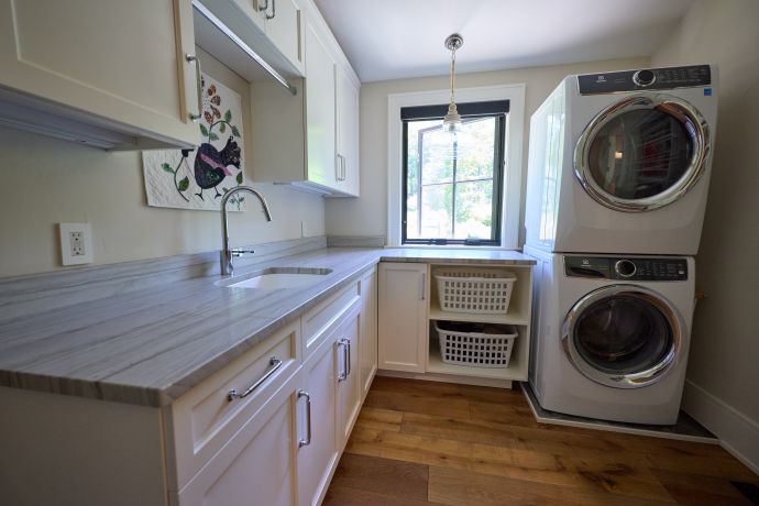 L-shaped laundry room with countertop and storage on one side