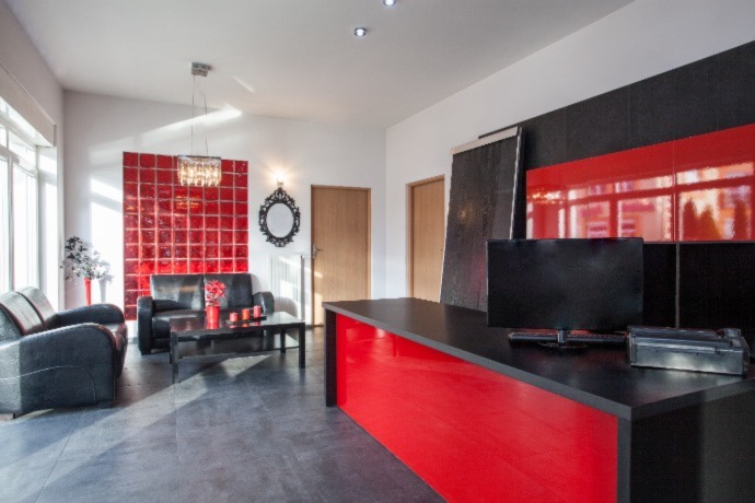 reception area with red color added to the desk and furniture
