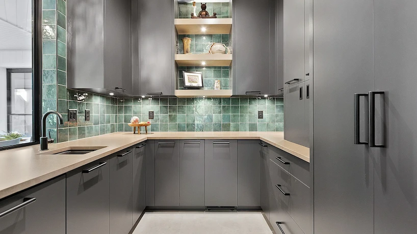 newly renovated kitchen with green backsplash and gray cabinetry