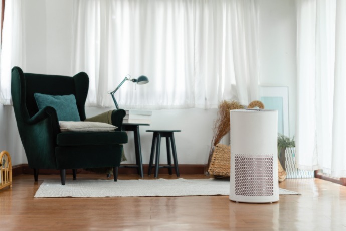 air purifier in the office space by a green chair