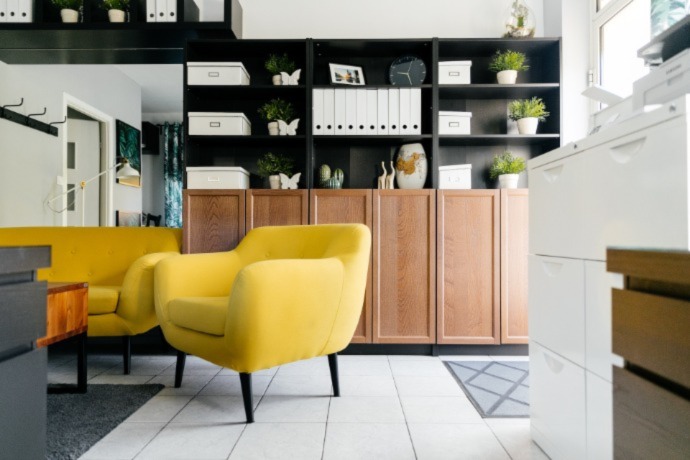 unique storage space in the office with big yellow arm chairs