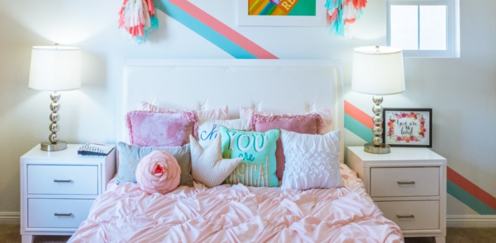 kids bedroom  with colorful pillows, pictures, and bedding 