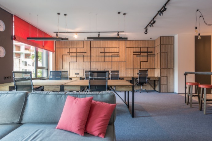 an office space with colorful pillows, couch and curtains