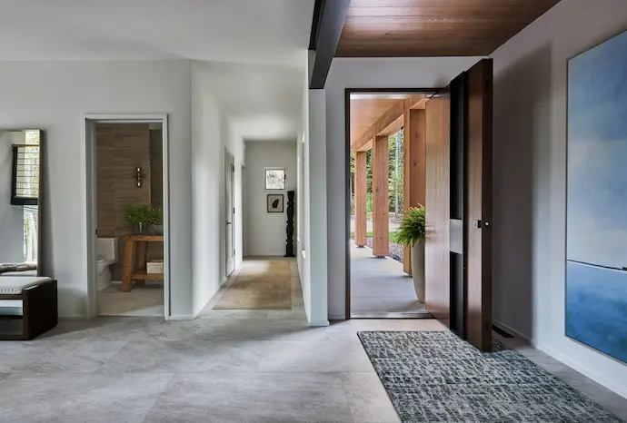 entryway with white shelves, clear door, hardwood floors