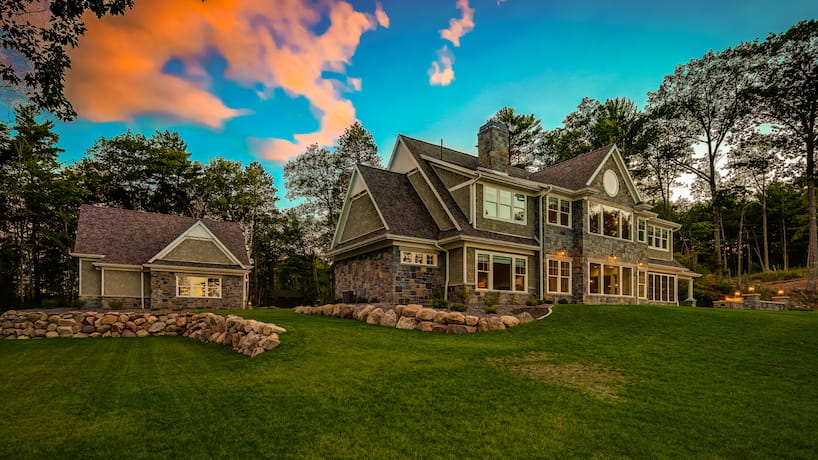 Dusk shot of newly built luxury home side view showing the scale of the home compared to the guest house