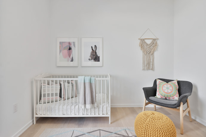 simple kids' bedroom with the bed, a desk on the right and some pictures on the wall