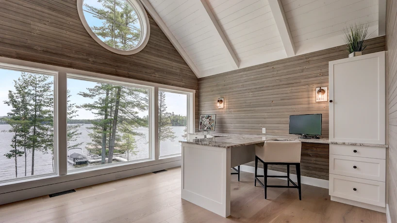 Newly renovated home office with wood flooring, granite desktop, and a massive window overlooking a bay