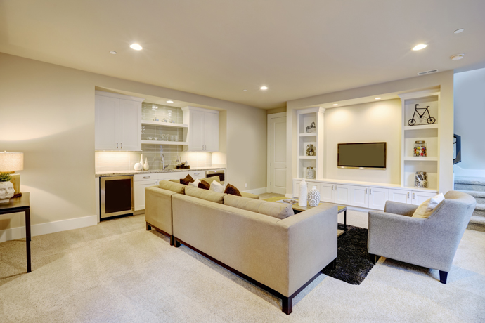 Remodeled finished basement with living room in cool blue tones and white accents.