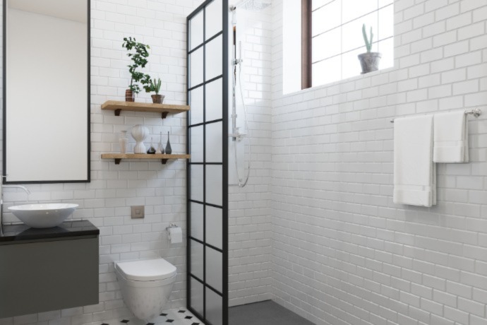 small bathrooms with brick tile and a big mirror, plants on the shelves