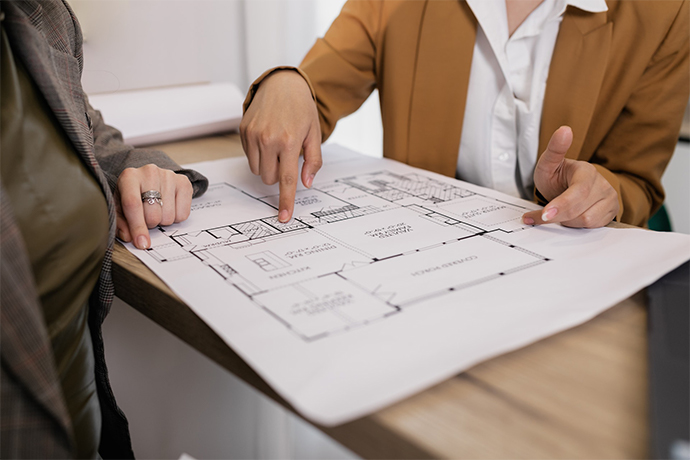 two people pointing to the construction plan