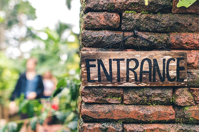 sign on the brick wall that says entrance