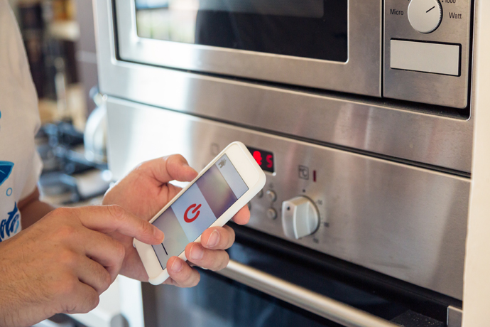 Man controlling his light and appliances through smart home app.