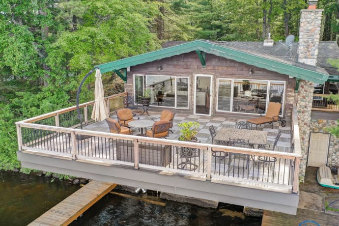 big house with a large deck overseeing the lake