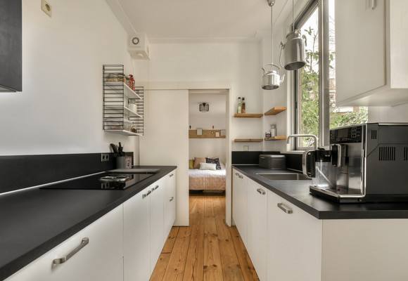 a kitchen with white cabinets and black counter tops on the counters in front of the oven, microwave, toaster and coffee maker