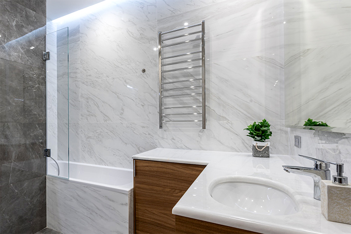 bathroom with heated towel rack next to the bath