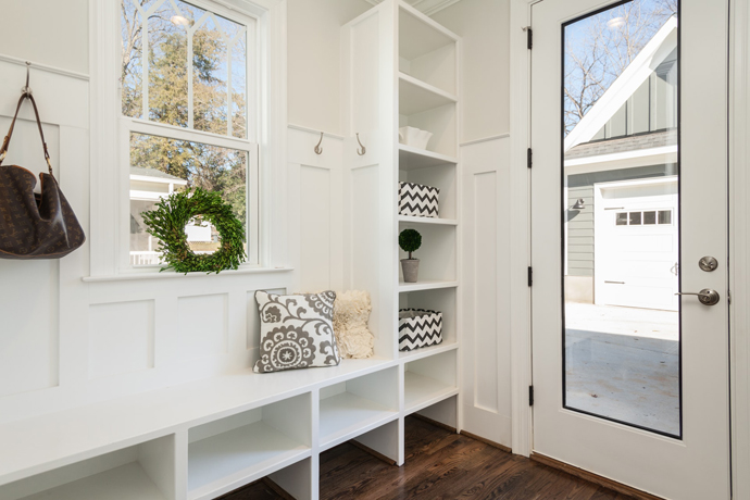 entryway with white shelves, clear door, hardwood floors