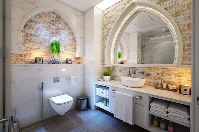 bathroom with lit up mirrors and brick wall