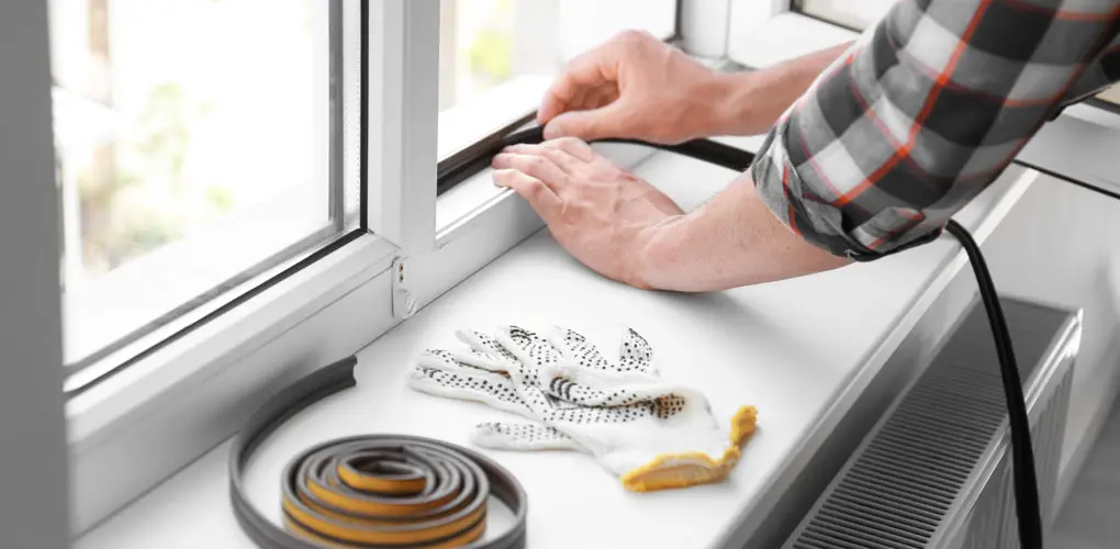 Installing weatherstripping for efficiency during summer.