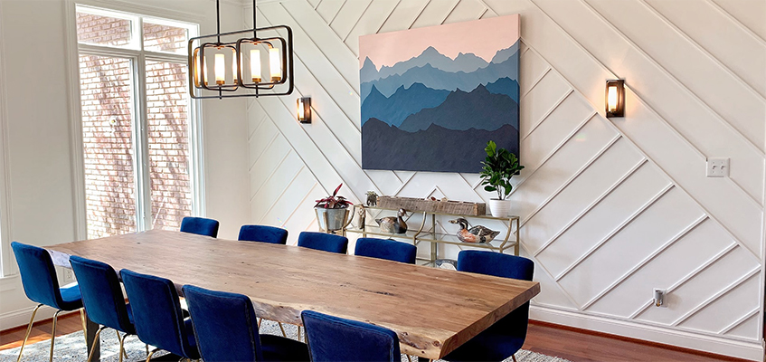 dinning room with big table, blue chairs, a big picture of the blue mountains on the wall