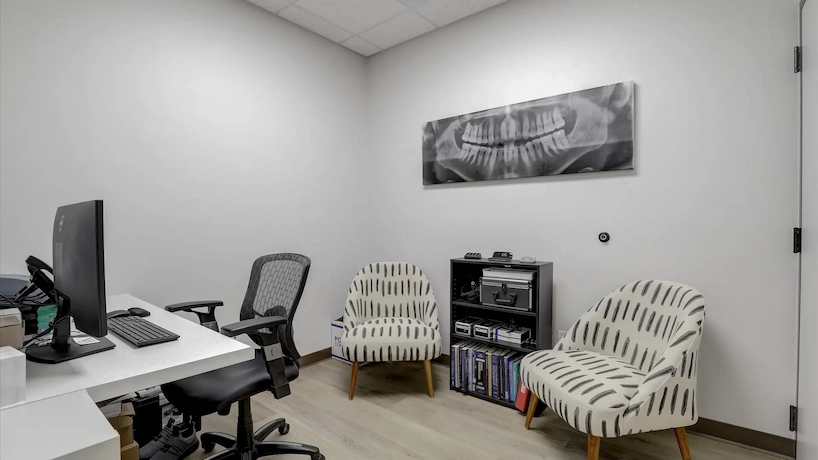 small new office space with grey walls, oak flooring and a white desk