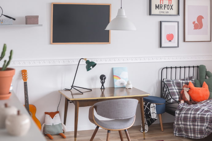 a focus corner in the bedroom with pictures on the wall and a crib