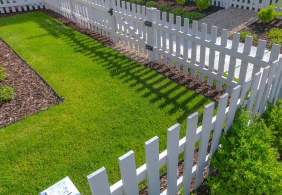white fence with a green lawn