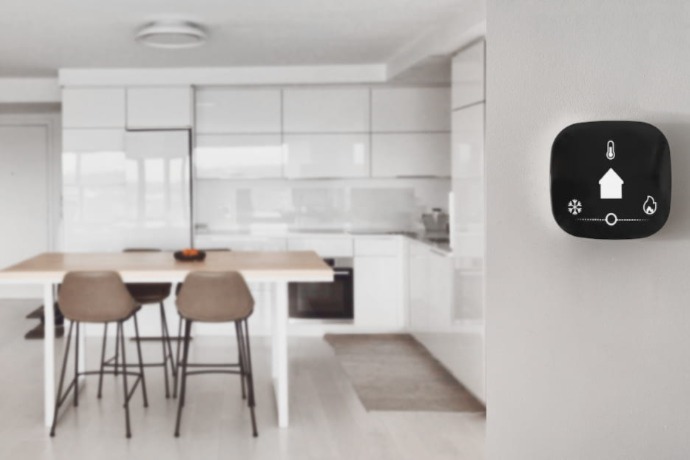 a kitchen area with a smart thermostat on the wall