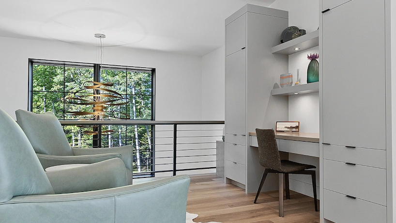 upstairs sitting area with a built in desk space and built it grey cabinets