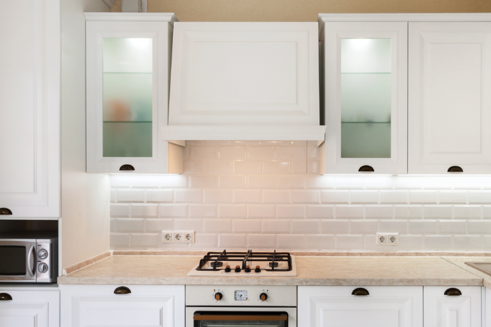 galley kitchen with lit up white cabinets