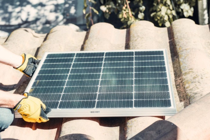 a person installing solar panels on the roof