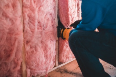a person adding insulation to the garage 