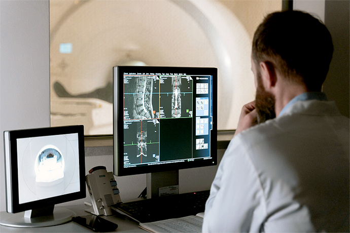 A doctor looking at the scree with patient's MRI scan 