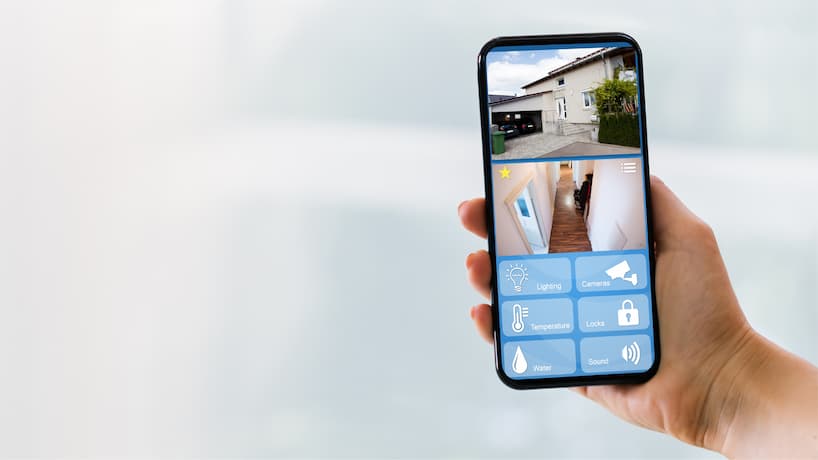 a hand holding a phone with a smart app for the house