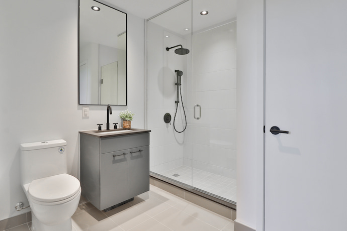 small bathroom after renovation with modern tile and grey sink cabinet 