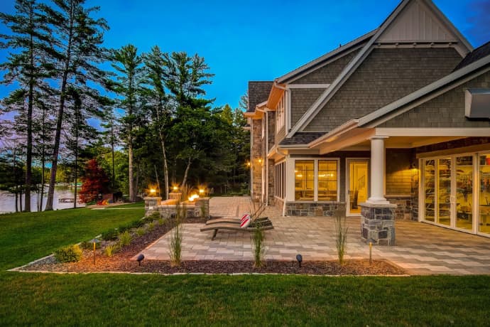 Big house with large patio at night by the lake