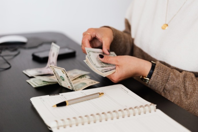 a person counting money to see what they can afford when building a dream home